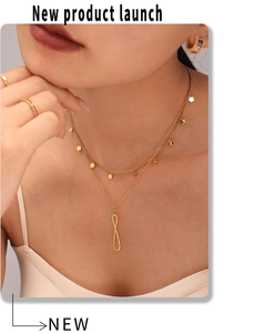 Close-up of double-layered gold necklace with sparkling infinity pendant on model