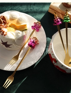 Detail of Christmas gold spoon and fork set with cartoon Santa and gingerbread toppers