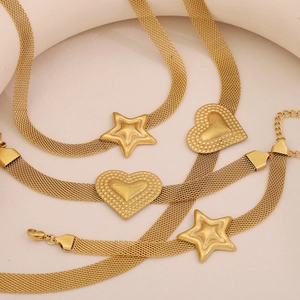 Gold stainless steel mesh necklace with heart and star charms on beige background