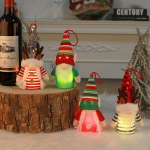 Set of four glowing Christmas gnome dolls with LED lights on rustic wooden stands