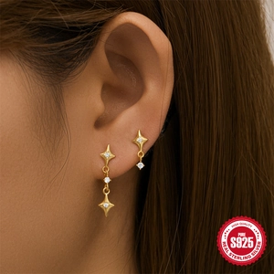 Close-up of gold S925 sterling silver star stud earrings with zircon on a model ear