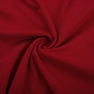 Vue détaillée du tissu en maille côtelée bordeaux avec texture rayée et toucher doux