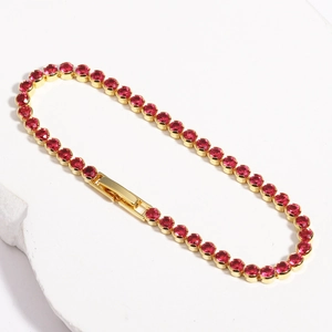 Detailed macro view of red crystal tennis bracelet with gold-plated micro-pave setting