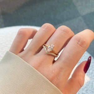 Close-up of a S925 silver gold-plated marquise cut diamond ring set worn on a hand