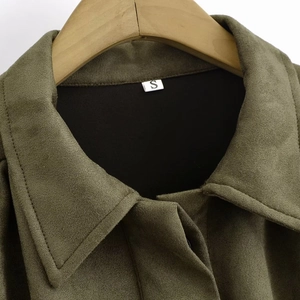 Close-up of military green suede jacket lapel with size S tag on a wooden hanger