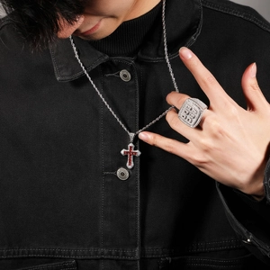 Hip hop silver necklace with cross pendant and large ring worn with black denim jacket