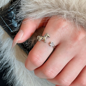Detailed close-up of a silver ring with a galloping horse charm and zircon star