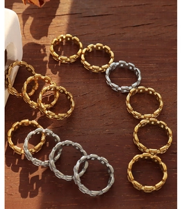 Detail of gold and silver chain link rings on wooden surface with natural light