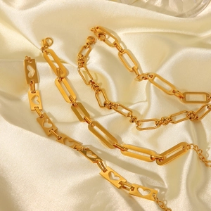 Detailed macro of 18K gold plated stainless steel hollow heart and geometric link chains