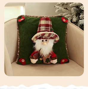 Detail of green Christmas pillow cover with 3D Santa Claus figure on a beige chair