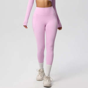 Close-up of pink high-waisted yoga leggings featuring side pockets and elastic fabric