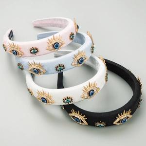 Dettaglio di quattro cerchietti imbottiti in jacquard con ciondoli Evil Eye dorati