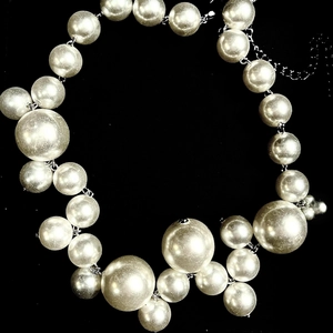 Macro detail of French vintage pearl necklace with gradient large silver beads on black