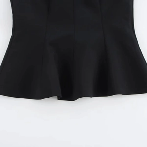 Detailed macro view of the black asymmetrical wave peplum hem design on sleeveless top