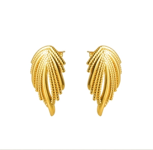 Détail de boucles d'oreilles dorées en forme d'ailes avec texture de plumes en acier