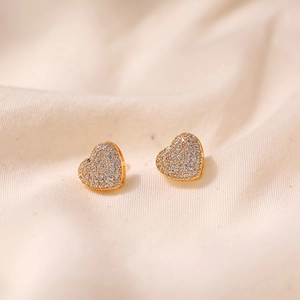 Close-up of heart-shaped gold studs with micro-pave white cubic zirconia stones