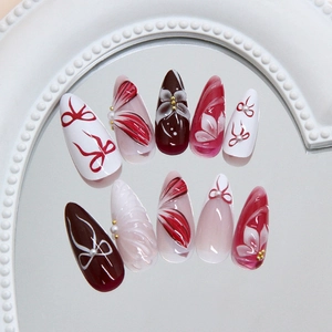 3D floral bow press-on nails with wine red and pearl accents on mirror tray