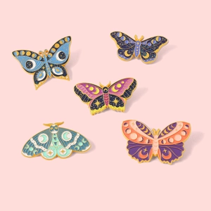 5-piece butterfly enamel pin set with celestial moon patterns on a pink background