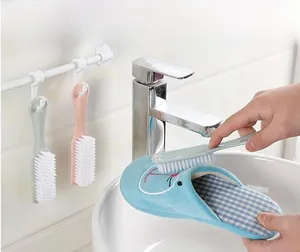 Dettaglio di una spazzola per bucato che pulisce una pantofola di cotone in un bagno
