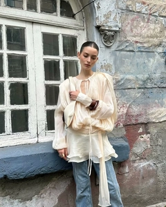 Detail of beige puff sleeve pleated top with drawstring ties for a vintage street style