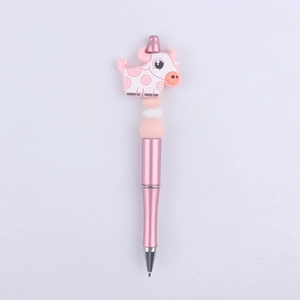 Detailed close-up of a pink beaded ballpoint pen featuring a cute silicone cow topper
