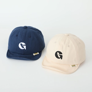 Close-up of navy and beige baby cotton baseball caps with embroidered G logo detail