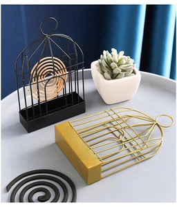 Birdcage mosquito coil holder in matte black and brushed gold iron frame on a table