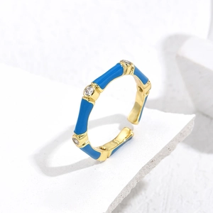 Detailed macro shot of gold plated bamboo style open ring with blue enamel and zircons