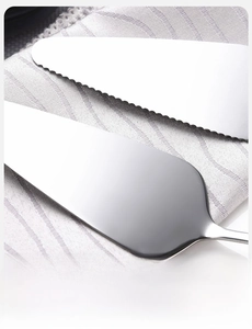 Macro shot of mirror-polished stainless steel cake server with sharp serrated edge