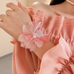 Close-up of pink tulle flower wristband with elegant pearls for a romantic bridal look