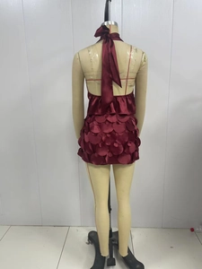 Détail du haut dos nu en satin bordeaux et jupe à paillettes à texture d'écailles