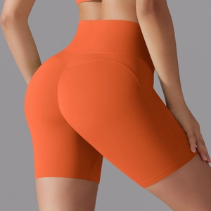 Detail view of high waisted orange yoga shorts featuring seamless butt lifting stitching