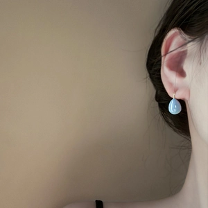 Boucles d'oreilles goutte bleu clair style français avec crochets dorés sur modèle
