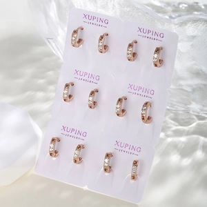 Set of six rose gold hoop earrings with white cubic zirconia on white display cards