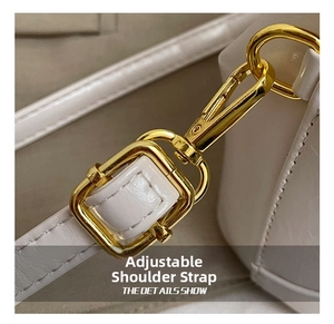 Close-up of golden metal buckle and white leather shoulder strap detailing for girls bag