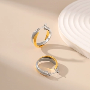 Two-tone gold and silver interlocking hoop earrings in a minimalist metal design