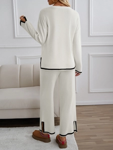 Detail view of white knit set featuring black trim and stylish side slits on wide-leg pants