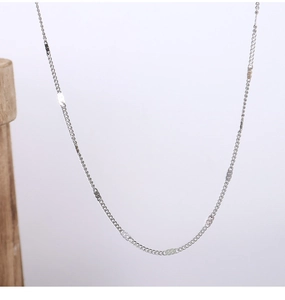 Close-up of minimalist silver titanium steel O-chain necklace against a clean background