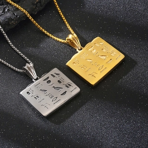 Detail of gold and silver square pendants with Egyptian hieroglyphs on metal box chains