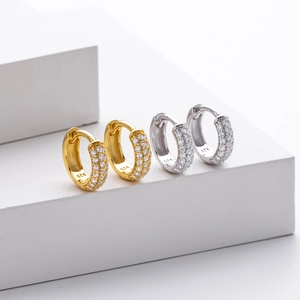 Macro shot of silver and gold S925 earrings with sparkling zircon pave setting