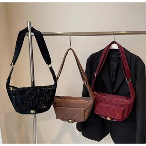Close-up of quilted glossy faux leather saddle bags in black, brown and burgundy colors
