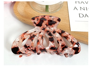 Detail of elegant tortoiseshell acetate hair claw clip with multi-teeth hollow structure