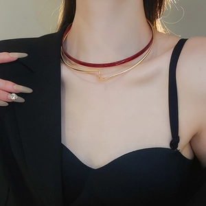 Close-up of a double-layered resin and gold metal collar necklace on a model