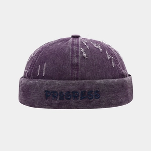 Détail du bonnet docker violet avec broderie Progress et finitions délavées vintage