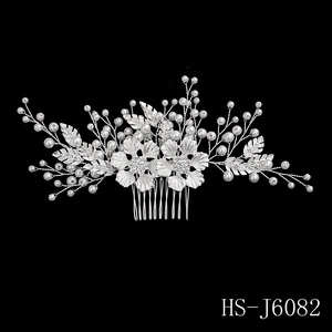 Detailed view of silver bridal hair comb with pearls and crystal leaf accents