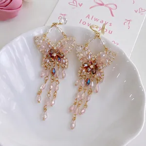 Boucles d'oreilles papillon élégantes avec cristaux roses dans un plateau coquille