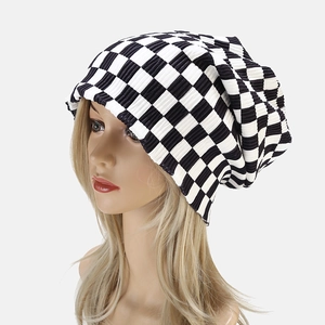 Detailed close-up of a black and white checkered knit beanie with ribbed texture