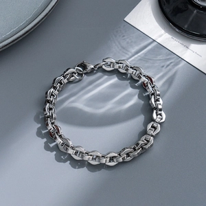 Macro view of interlocking silver stainless steel chain bracelet with industrial finish