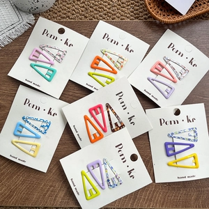Three-piece colorful triangle BB hair clips with floral and polka dot patterns on card