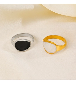 Detail of adjustable gold and silver rings with black and white enamel finish on fabric